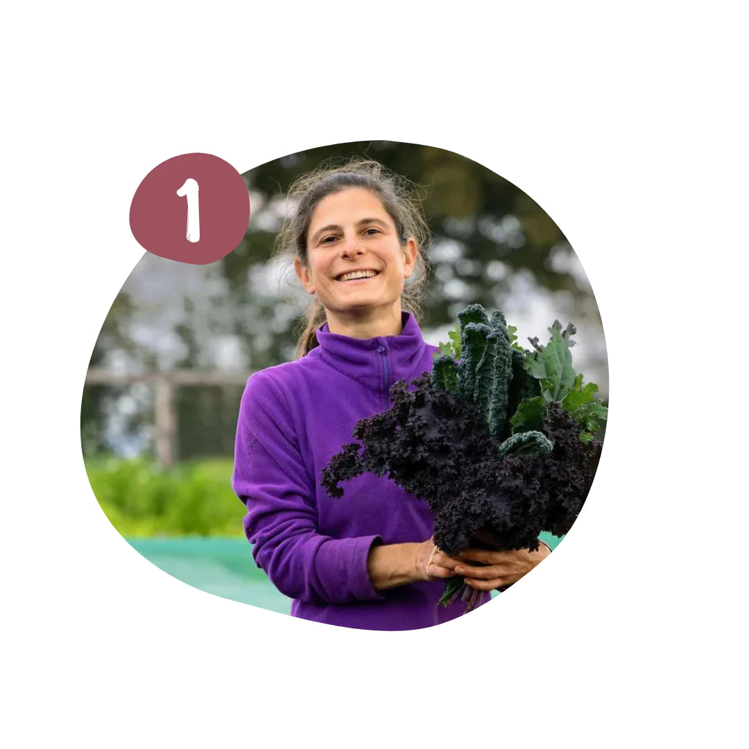 Image of female farmer holding seasonal cavolo nero and kale